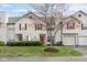 Charming townhome featuring red shutters, front lawn with manicured bushes, and an attached garage at 6014 Wildcat Dr, Indianapolis, IN 46203