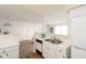 Open concept kitchen with stainless steel sink, white appliances and a view to the living area at 6014 Wildcat Dr, Indianapolis, IN 46203