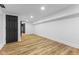 Unfurnished basement featuring wood look floors and white walls at 6470 Jackson St, Indianapolis, IN 46241