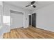 Bedroom with wood-look flooring, neutral walls, ceiling fan, and closet access at 6470 Jackson St, Indianapolis, IN 46241