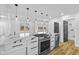 Modern kitchen features a large island with a cooktop, white cabinetry, and pendant lighting at 6470 Jackson St, Indianapolis, IN 46241