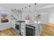 Bright kitchen boasts an island with cooktop, waterfall countertops, and stainless steel appliances at 6470 Jackson St, Indianapolis, IN 46241
