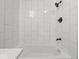 Bathroom bathtub and shower featuring modern fixtures and bright, white tile at 718 Indiana Ave, Shelbyville, IN 46176