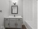 Charming bathroom with gray cabinets, modern fixtures, and a bathtub and shower with white tile at 718 Indiana Ave, Shelbyville, IN 46176