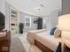 Bedroom with bed, grey walls, white trim, carpeting, large window, and access to bathroom at 718 Indiana Ave, Shelbyville, IN 46176