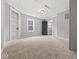 Bedroom with gray walls, carpeting, a window, built-in shelving, and access to bathroom at 718 Indiana Ave, Shelbyville, IN 46176