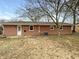 The rear exterior of the brick home has a door to the backyard, and 3 windows at 719 Howard Rd, Greenwood, IN 46142