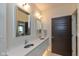 Bathroom featuring double vanity with sleek mirrors and a dark wood door at 802 N Meridian St # 205, Indianapolis, IN 46204