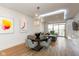 Dining area with modern chandelier, hardwood floors, and views to the living room and balcony at 802 N Meridian St # 205, Indianapolis, IN 46204