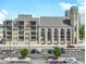 An exterior view of a modern apartment building attached to a historic church with ample parking at 802 N Meridian St # 205, Indianapolis, IN 46204