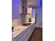 Modern white kitchen with flat cooktop stove, stainless steel range hood, and marble countertops at 802 N Meridian St # 205, Indianapolis, IN 46204
