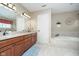 Bright bathroom features dual sinks, vanity, and a soaking tub beneath a large window at 8238 Armadale Ct, Indianapolis, IN 46236