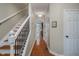 Hallway featuring hardwood floors, white trim, wrought iron railing staircase and multiple doorways at 8238 Armadale Ct, Indianapolis, IN 46236
