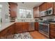 Kitchen showcasing granite countertops, wood cabinets, stainless steel appliances, and tile backsplash at 8238 Armadale Ct, Indianapolis, IN 46236