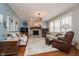Cozy living room with brick fireplace, hardwood floors, and large windows for natural light at 8238 Armadale Ct, Indianapolis, IN 46236