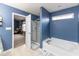 Blue bathroom featuring a bathtub, glass-enclosed shower, and access to the living room at 8430 Templederry Dr, Brownsburg, IN 46112