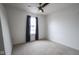 An empty bedroom with neutral carpet and a large window with dark curtains at 9769 Green Knoll Dr, Noblesville, IN 46060