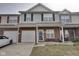 Traditional townhome with brick facade, vinyl siding, attached garage, and well-maintained lawn at 9769 Green Knoll Dr, Noblesville, IN 46060