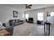 Bright living room with carpet, ceiling fan, and two sofas. Light from two large windows at 9769 Green Knoll Dr, Noblesville, IN 46060