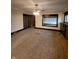 Large living room with carpet flooring, a vintage ceiling fan, and decorative glass windows at 1001 S Anderson St, Elwood, IN 46036