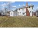 This backyard features a detached garage and white house with brick chimney at 1023 W 7Th St, Anderson, IN 46016
