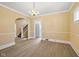 A neutral living area with hardwood floors that lead to a staircase and kitchen at 1023 W 7Th St, Anderson, IN 46016