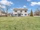 Exterior view of the home's backyard with a screened porch, grassy lawn, and mature trees at 10827 Putnam Pl, Carmel, IN 46032