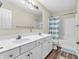 Bright bathroom featuring a double sink vanity, large mirror, and a shower/tub combination with a striped curtain at 10827 Putnam Pl, Carmel, IN 46032