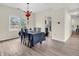Bright dining room featuring wood-look floors, natural light, and access to kitchen at 10827 Putnam Pl, Carmel, IN 46032
