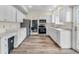 Well-lit kitchen features white cabinets, stainless steel appliances, and wood-look floors at 10827 Putnam Pl, Carmel, IN 46032