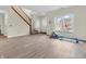Open-concept living room features wood-look floors, staircase, and natural light from a large window at 10827 Putnam Pl, Carmel, IN 46032