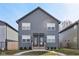 Front elevation of a charming two-story duplex with an inviting entrance, tidy front lawns, and gray siding at 139 Mckim Ave, Indianapolis, IN 46201