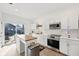 Bright kitchen features white cabinets, stainless steel appliances, island, and sliding doors to the patio at 139 Mckim Ave, Indianapolis, IN 46201