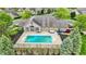 Aerial view of fenced pool area, patio, seating, landscaping, and community building at 13902 Rue Royale Ln # 62, McCordsville, IN 46055