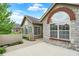Charming stone home exterior featuring a brick arch above the window, lush trees, and manicured landscaping at 13902 Rue Royale Ln # 62, McCordsville, IN 46055