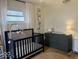 Charming Bedroom with black crib, neutral decor, and natural light from the window at 2104 W Barcelona Dr, Muncie, IN 47304