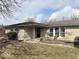 Charming single-story home featuring a covered entry, stone facade and well-kept lawn at 2104 W Barcelona Dr, Muncie, IN 47304