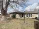 Charming home exterior with stone facade, well-manicured front yard, and mature tree at 2104 W Barcelona Dr, Muncie, IN 47304