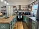 Bright kitchen with updated stainless steel appliances, green cabinets, butcher block countertops, and decorative shelves at 2104 W Barcelona Dr, Muncie, IN 47304