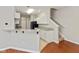 Modern kitchen with granite countertops, white cabinets, and black appliances, adjacent to the staircase at 2218 Colfax Ln, Indianapolis, IN 46260