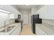 Efficient galley kitchen with white cabinets, black appliances, and granite countertops for a sleek design at 2218 Colfax Ln, Indianapolis, IN 46260