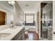 Bathroom with a tiled shower, bathtub, double sink vanity, and wood floors at 2308 Nowland Ave, Indianapolis, IN 46201