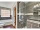 Tiled shower and tub combination in bathroom features wood floors, and glass doors at 2308 Nowland Ave, Indianapolis, IN 46201