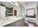 Bathroom features double sink vanity, wood floors, and tiled bathtub and shower at 2308 Nowland Ave, Indianapolis, IN 46201