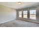 Empty bedroom with carpet, neutral walls, and three large windows at 2308 Nowland Ave, Indianapolis, IN 46201
