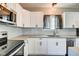 Well-lit kitchen with white cabinets, stainless steel appliances, quartz countertops, and subway tile backsplash at 2308 Nowland Ave, Indianapolis, IN 46201