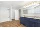 A blue vanity with dual sinks alongside a tub and shower combo at 3113 Cassara Dr, Indianapolis, IN 46203