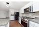 Renovated kitchen features stainless steel appliances, granite countertops, white cabinets, and modern lighting at 3113 Cassara Dr, Indianapolis, IN 46203