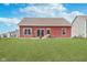 Backyard features a patio, green lawn, and a charming red home with modern sliding glass doors at 389 Longleaf Ln, Greenfield, IN 46140