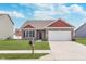 Charming single-Gathering home showcasing a well-manicured lawn and a two-car attached garage at 389 Longleaf Ln, Greenfield, IN 46140